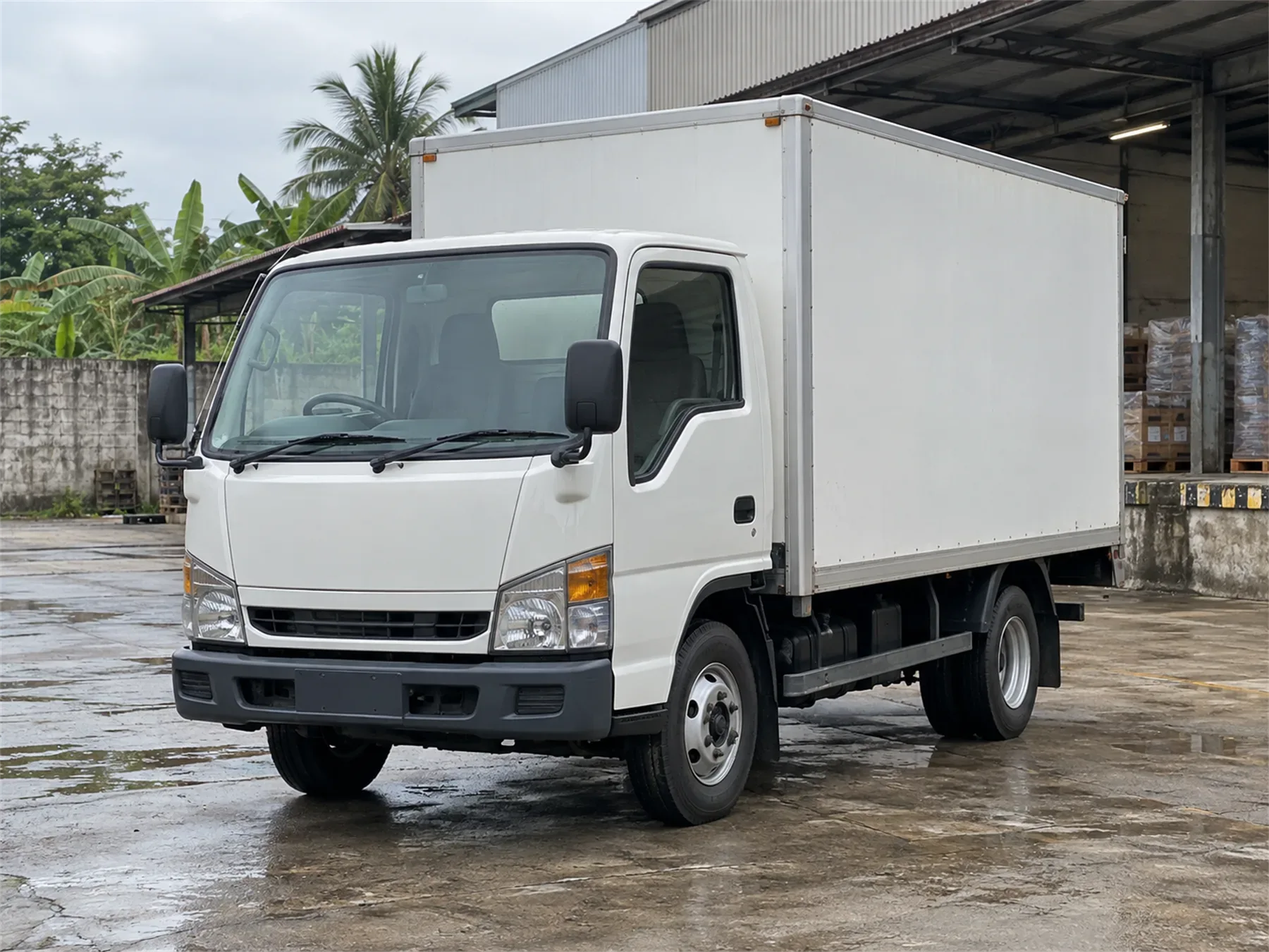 Truk CDE box berwarna putih di halaman gudang