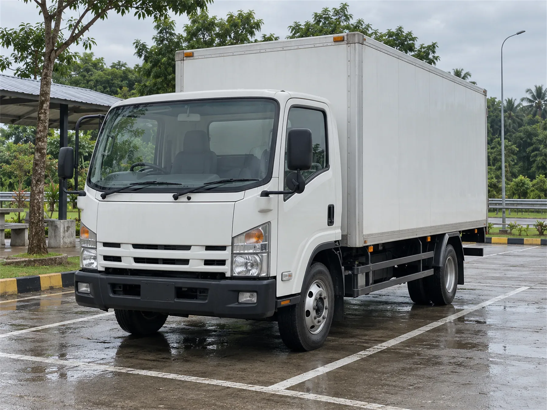 Truk CDD box berwarna putih terparkir di area operasional